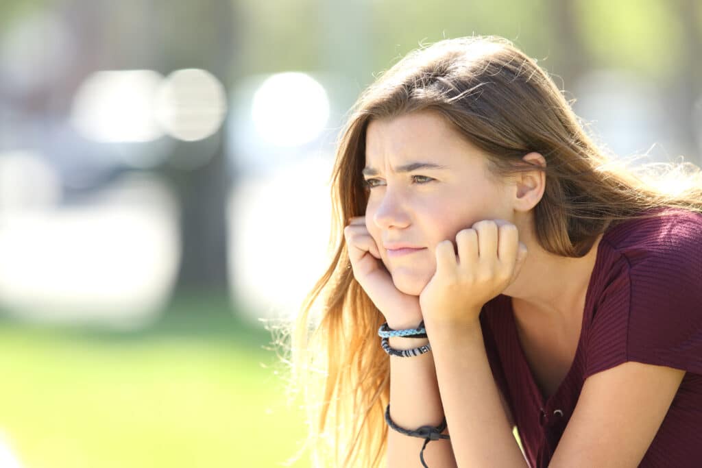 Portrait Of An Angry Teen Looking Away Sitting Alone Outside